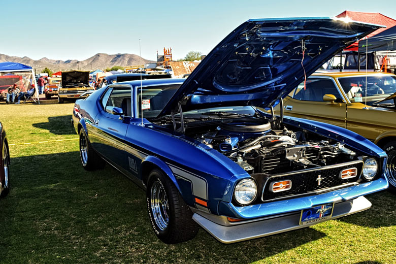 a blue car on display in a car show